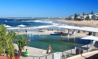 a large body of water with several people enjoying the sunny day at a beach at Kings Row Apartments