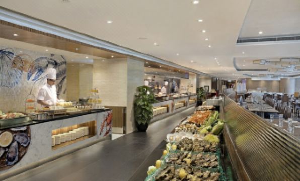 The restaurant features a wide variety of food displayed on the counter, complemented by an open concept layout at The Kowloon Hotel