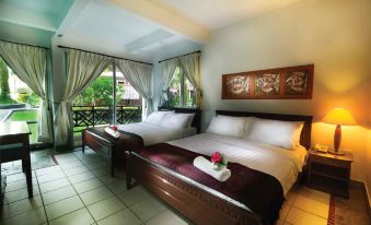 a bedroom with two beds , one on each side of the room , and a window overlooking a garden at Paya Beach Spa & Dive Resort
