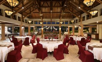 A spacious room is arranged with tables and chairs for hosting events at a hotel or banquet at Aryaduta Bandung