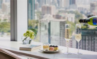 On the table, there is a tray holding an assortment of glasses and plates at Cordis, Hong Kong