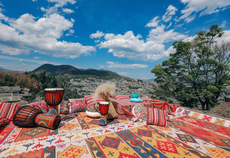 A picturesque view of mountains in the background, complemented by red pillows on each side at Lijiang YueJiaren · White Horse Luxury Homestay