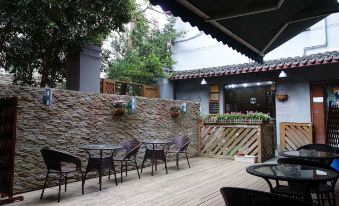 An outdoor patio with tables and chairs also features a small bar on the side at Beehome  Hostel