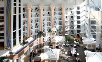 a large hotel lobby with high ceilings , multiple rows of chairs , and multiple tables set up for meetings or events at Central Hotel