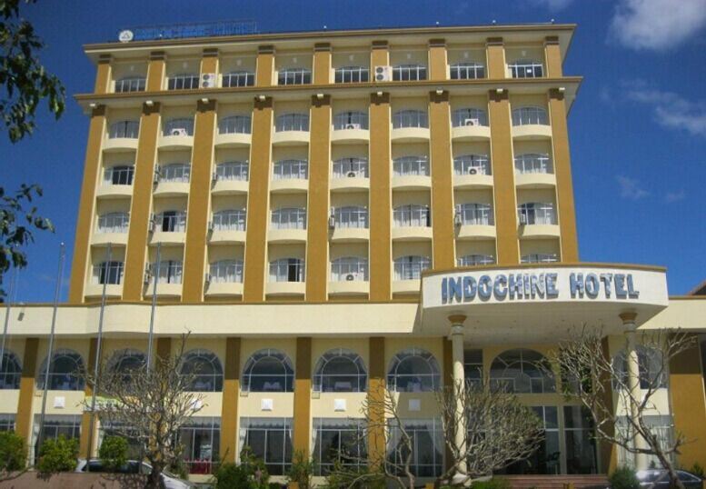 "a large , yellow building with white trim and the name "" indochina hotel "" written in blue" at Indochine Hotel