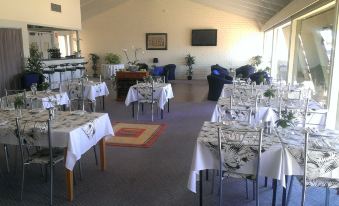 a large dining room with tables and chairs set up for a party or event at Lindy Lodge Motel