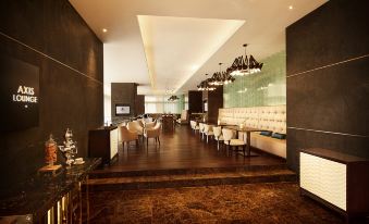 a modern dining room with a long table and chairs , chandeliers hanging from the ceiling , and large windows at DoubleTree by Hilton Melaka