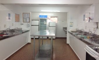 a clean , well - organized kitchen with stainless steel appliances and a table in the center at All Seasons Holiday Park