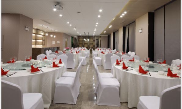 A spacious room is arranged with tables and chairs for hosting events or functions at Jinfan Wanyuan Hotel