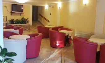 a modern living room with red and white furniture , a staircase , and a television on the wall at All Inclusive Hotel Piccolo Paradiso