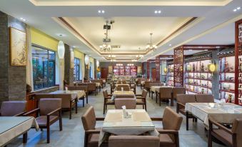 The restaurant features a spacious dining room with tables and chairs arranged in the center, ideal for business luncheons at Zhenmei Resort Chain Hotel(Yangshuo West Street AiYuan Store)