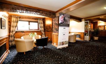 a room with a large window , wooden walls , and a reception desk featuring a black and white advertisement at Fairways Lodge & Leisure Club