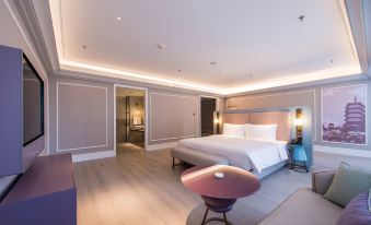 a modern hotel room with a large bed , wooden floors , and a bathroom visible through a glass door at Hengxing Mercure Hotel