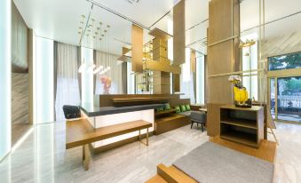 a modern hotel lobby with wooden benches , a reception desk , and a staircase leading to the second floor at Ibis Styles Hotel