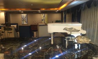 a white grand piano is placed on a marble table in a room with chairs , paintings , and a painting on the wall at Madison Hotel