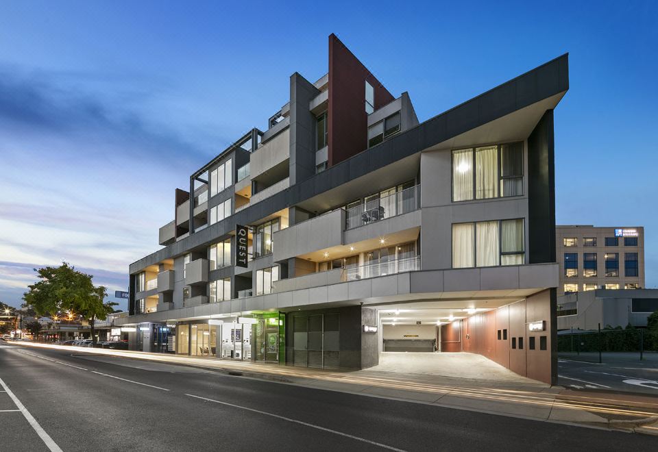 a modern apartment building with multiple balconies and large windows , situated on a city street at Quest Cheltenham