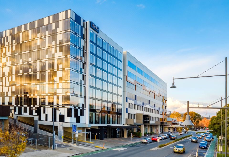 a modern building with a unique facade , located in a city environment with cars on the road at Mantra Albury Hotel