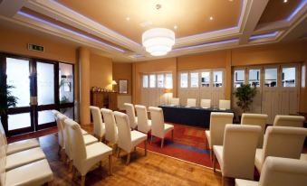 a conference room with rows of chairs and a long table set up for an event at Majestic Hotel