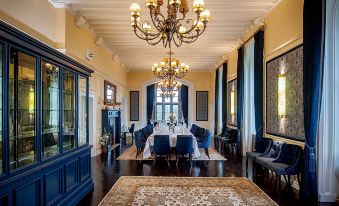 a large dining room with a long table , blue chairs , and a chandelier hanging from the ceiling at Kilkea Castle