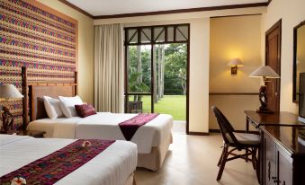 a hotel room with two beds , one on the left side of the room and the other on the right side at Holiday Resort Lombok