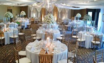a large , elegant banquet hall filled with round tables and chairs , set for a wedding reception at Best Western Pembroke Inn  Conference Centre