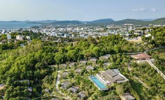 aerial view of a small village surrounded by trees and mountains , with a pool in the middle of the area at Lahana Resort Phu Quoc & Spa