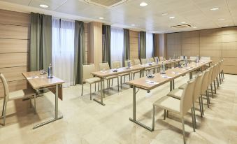 A spacious dining area with matching tables and chairs for meals or other similar activities at NH Logrono Herencia Rioja