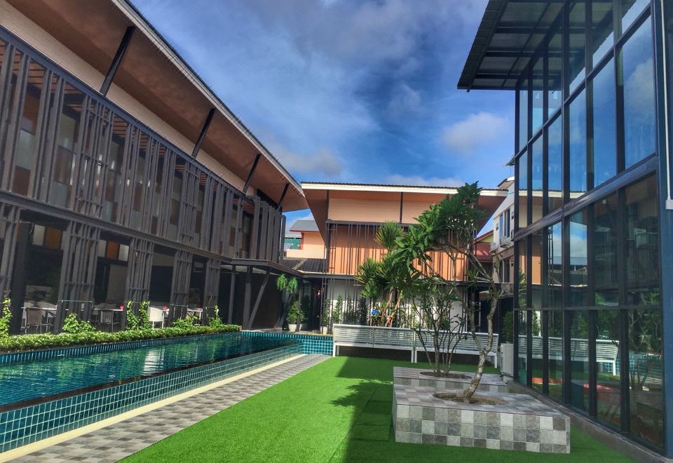 a modern building with a large glass window and a grassy area near a swimming pool at Blue Lagoon Hotel