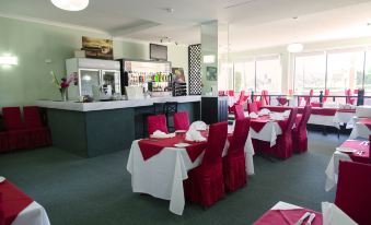 a dining room with tables and chairs arranged for a group of people to enjoy a meal together at Ryde Inn