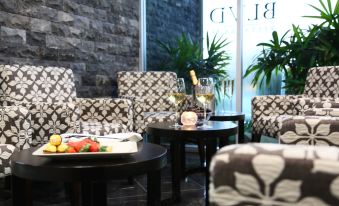 a room with a table set for two people , surrounded by chairs and a couch at Springfield Lakes Boutique Hotel