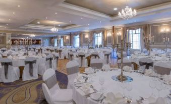 a large banquet hall with white tablecloths , chairs , and tables set up for a formal event at Talbot Hotel Wexford