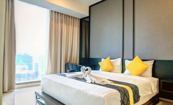 One end of the area is a bedroom with two beds and a large window that overlooks the city at Tropicana The Residences KLCC by Vale Pine