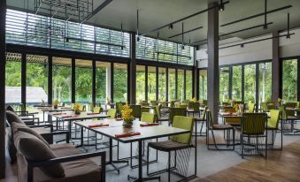 a large dining room with multiple tables and chairs arranged for a group of people at Mida Resort Kanchanaburi