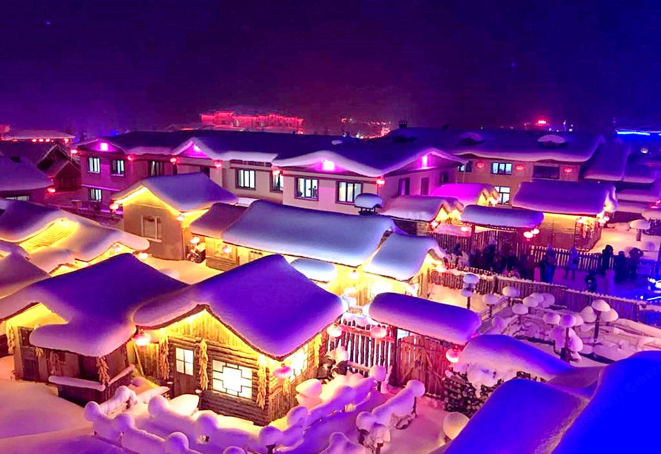 At night, a snow-covered city is adorned with lights from top to bottom at Xiaoguo Travellers' Home