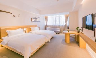 The bedroom features double beds, large windows, and a table in the center at Ceramik Hotel (Foshan Lecong Furniture City)