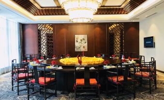 a large dining table is set with plates , chairs , and a fruit bowl in the center at Orient Hotel