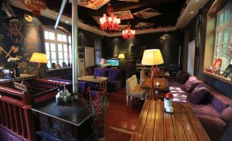 The room features wooden furniture and tables, as well as an old-fashioned bar at 7 Sages International Youth Hostel