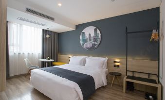 The bedroom features a spacious bed and a chair positioned in the center, with an adjacent open doorway at Jimu Xiaozhu Hotel (Shanghai Jing'an Temple)