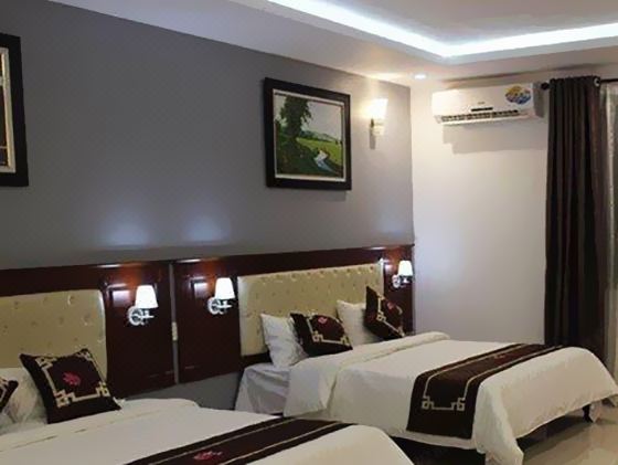 a hotel room with two beds , a painting on the wall , and an air conditioner at Paradise Hotel Bac Kan