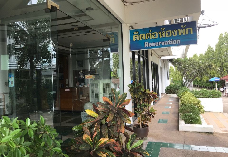 "a building with a sign that says "" reservation "" and several potted plants in front of it" at Triple Resort