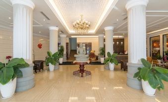 a grand hotel lobby with high ceilings , multiple columns , and a grand piano in the center at Paradise Hotel