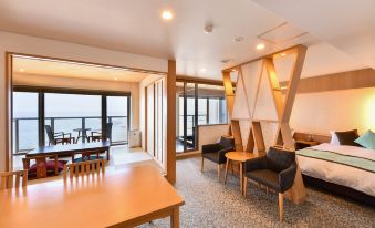 a modern living room with wooden furniture , including a dining table and chairs , and large windows overlooking the ocean at OARAI HOTEL