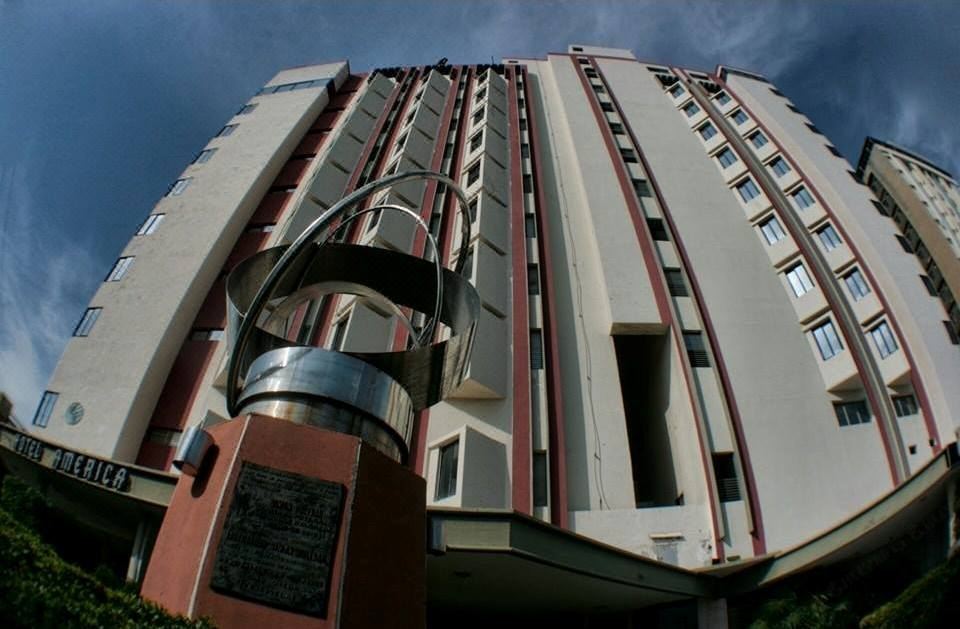 a tall building with a red and white facade is shown from a low angle at America