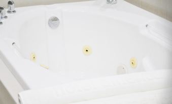 a white bathtub with a faucet and three yellow dots on the side is shown at America