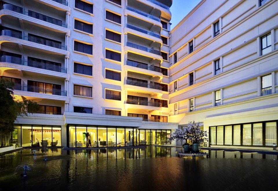 A two-story building is situated beside another, illustrating the water level at Jinjiang Metropolo Classiq Jing'An Hotel