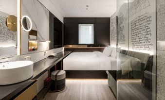 A modern bedroom with a large bed and a small sitting area in the middle, elevated at CitiGO Hotel Sanyuanqiao Beijing