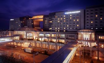 "a large hotel with a modern design and the name "" hotel ac hotel iwant "" is illuminated at night" at Hotel Nikko Kansai Airport