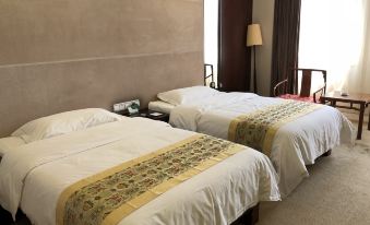 a hotel room with two beds , one on the left and one on the right side of the room at Spring Hotel