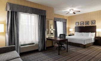 a hotel room with a bed , desk , and window , decorated in a modern style with wooden paneling at Homewood Suites by Hilton Newtown - Langhorne