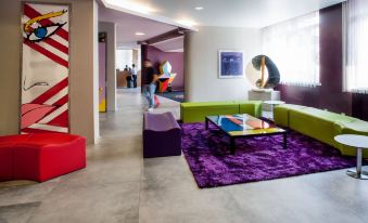 a colorful living room with various furniture , including couches , chairs , and a dining table at Hotel Da Vinci